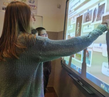 dziewczyna dotyka tablicy interaktywnej