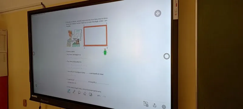 Ekran interaktywny wyświetlający stronę internetową z ilustracją i tekstem w języku polskim.