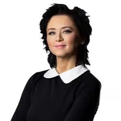 Kobieta o krótkich, ciemnych włosach w czarnej bluzce z białym kołnierzykiem na białym tle.