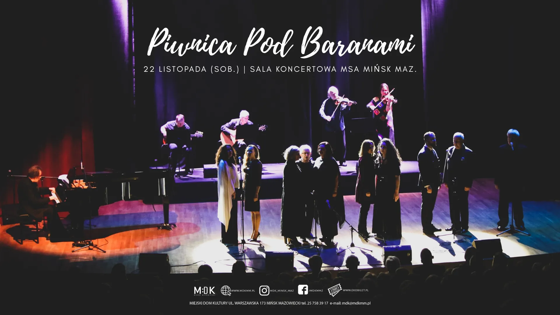 Kliknięcie powiększy obraz. Grupa muzyków i śpiewaków na scenie w sali koncertowej, oświetlonych jasnymi reflektorami, z ciemnym tłem i fioletowymi zasłonami. Po lewej stronie pianista przy fortepianie, w tle dwóch gitarzystów i dwóch skrzypków. Na pierwszym planie dziewięć osób stojących przed mikrofonami. Publiczność widoczna w cieniach na dole zdjęcia. Tekst zapowiadający wydarzenie „Piwinca Pod Baranami” oraz datę i miejsce koncertu.