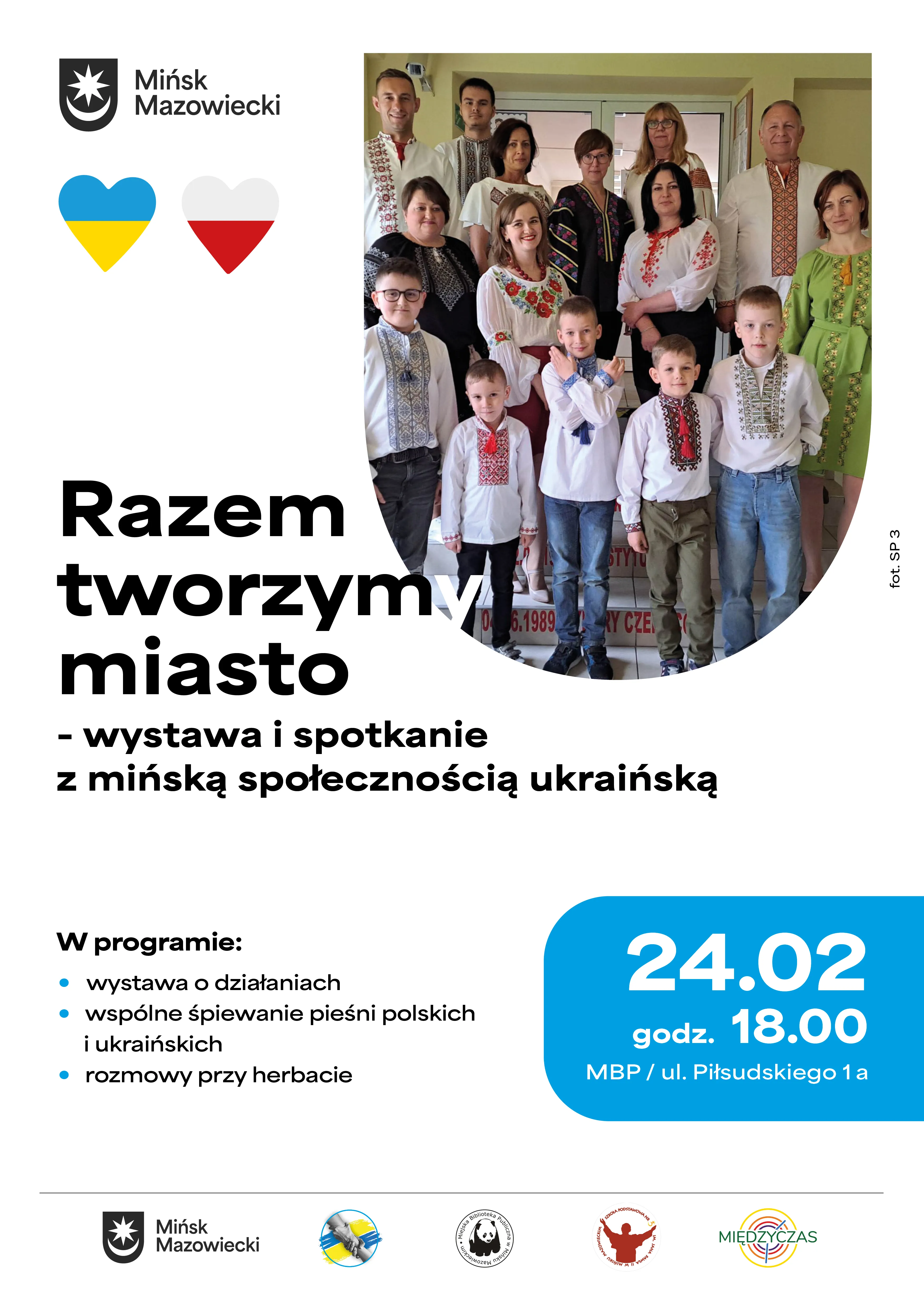 Kliknięcie powiększy obraz. Grupa kilkunastu osób w przedsionku, dorośli i dzieci stoją w kilku rzędach. Wszyscy noszą haftowane tradycyjne koszule i jasne ubrania. Po lewej u góry widoczne jest logo miasta i dwa serca w kolorach Ukrainy i Polski. Plakat ma biało-niebieskie tło i wyraźne niebieskie pole z datą wydarzenia. Na dole widoczne są logotypy organizatorów.